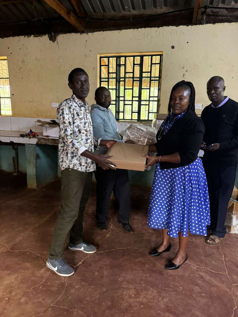 Community members receiving computer equipment for digital literacy program